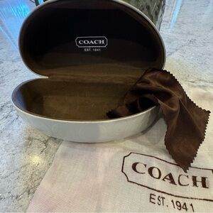 White, signature, Coach, clamshell sunglasses case.
